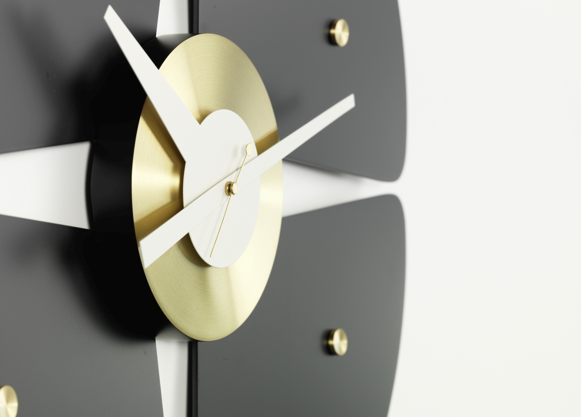 Detailaufnahme der Petal Clock Wanduhr von Vitra mit goldenem Ziffernblatt und schwarzen Blütenblättern.