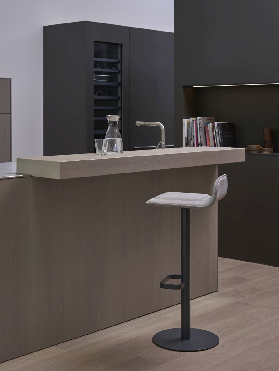 Anthrazitfarbener Barhocker mit hellgrauem Sitzpolster, Modell Dave, vor einer modernen Kücheninsel.