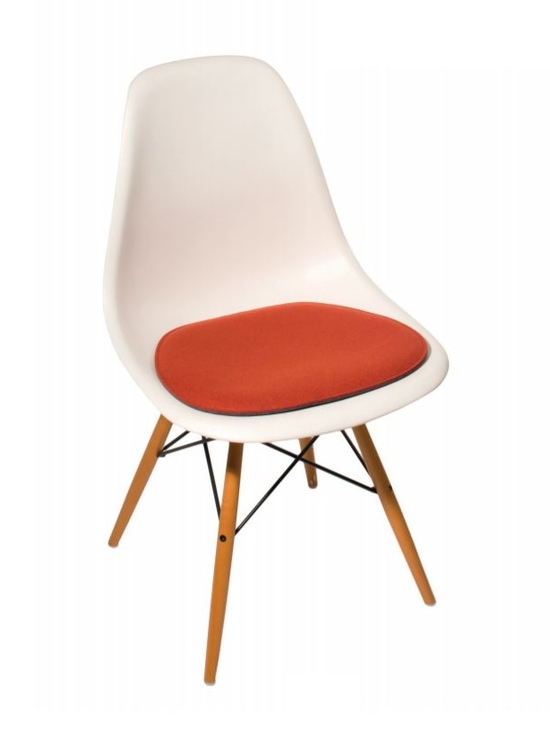 Weißer Eames Side Chair mit orangefarbenem Sitzkissen, Holzbeinen und schwarzem Metallgestell. Sitzschale aus Kunststoff.