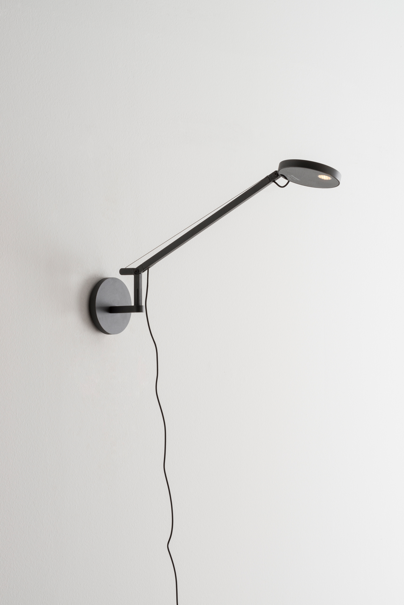 Anthrazitgraue Demetra Micro Wandleuchte von Artemide mit verstellbarem Arm und LED-Licht. Wandlampe für Schlafzimmer.
