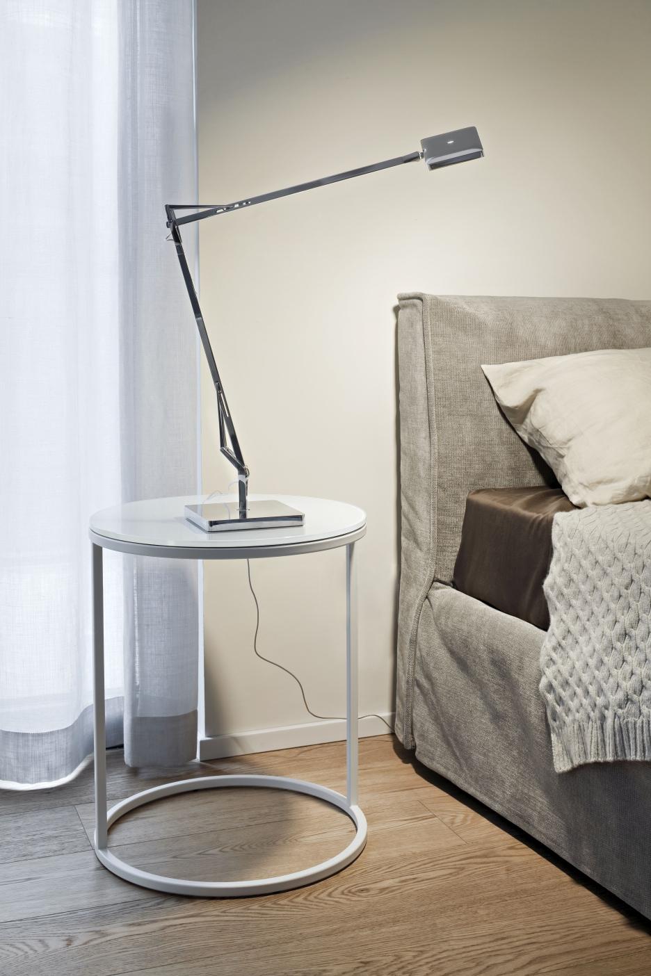 Weiße Kelvin Edge Tischleuchte von Flos auf Nachttisch neben Bett im Schlafzimmer.