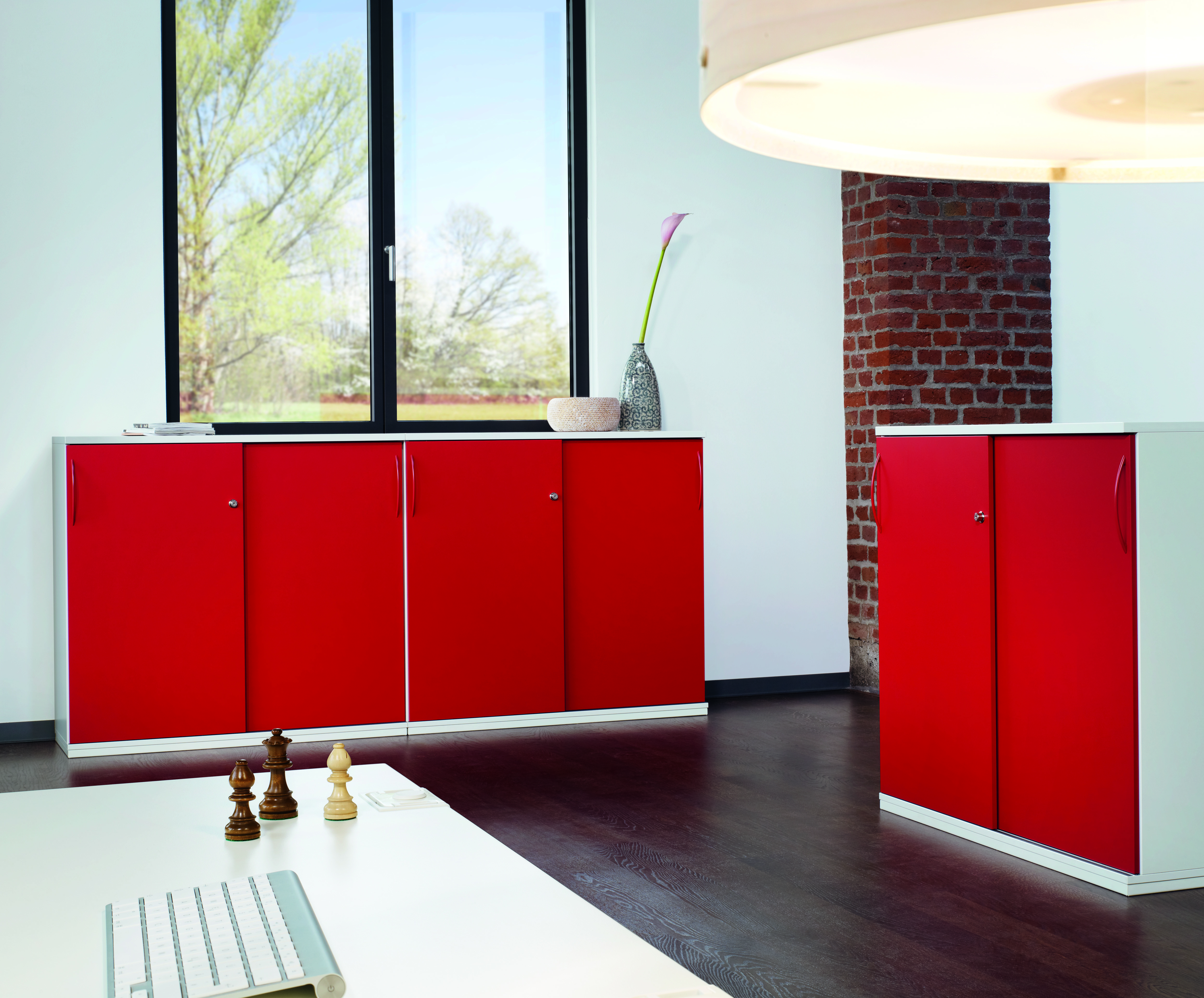 Roter Acta Schiebetürenschrank von König+Neurath im Büro, Büromöbel zur Aufbewahrung von Akten.