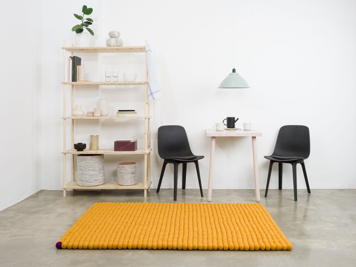 Ockergelber Filzteppich "Big One" von myfelt, 180x260 cm, im minimalistischen Wohnraum.