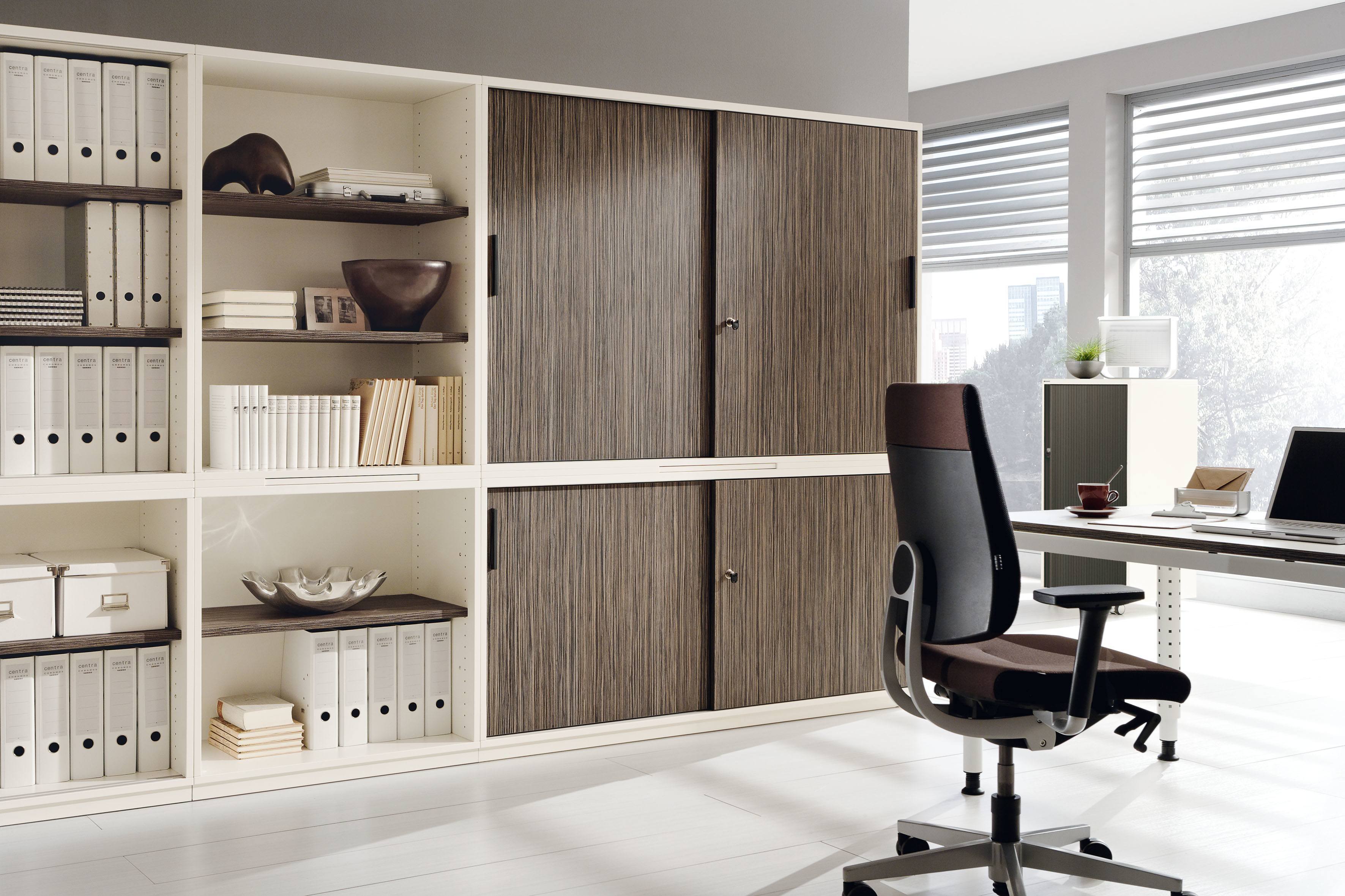 Büro mit Palmberg Querrollladenschrank Prisma 2, Regalen, Büromöbeln und Schreibtisch für moderne Arbeitsplatzgestaltung.