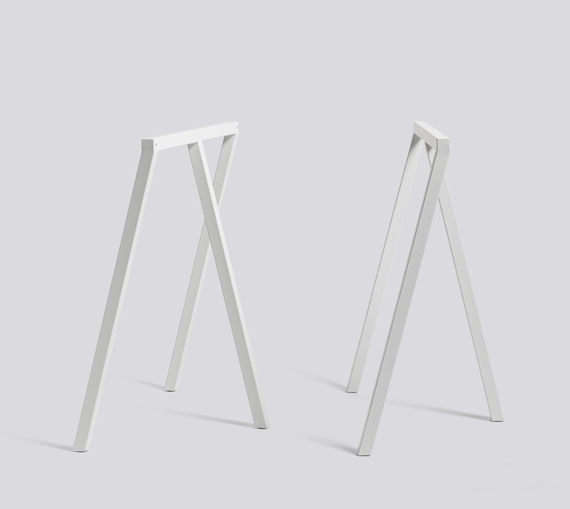 Zwei weiße Loop Stand Frame Böcke von Hay, ideal für Schreibtische und Tische.