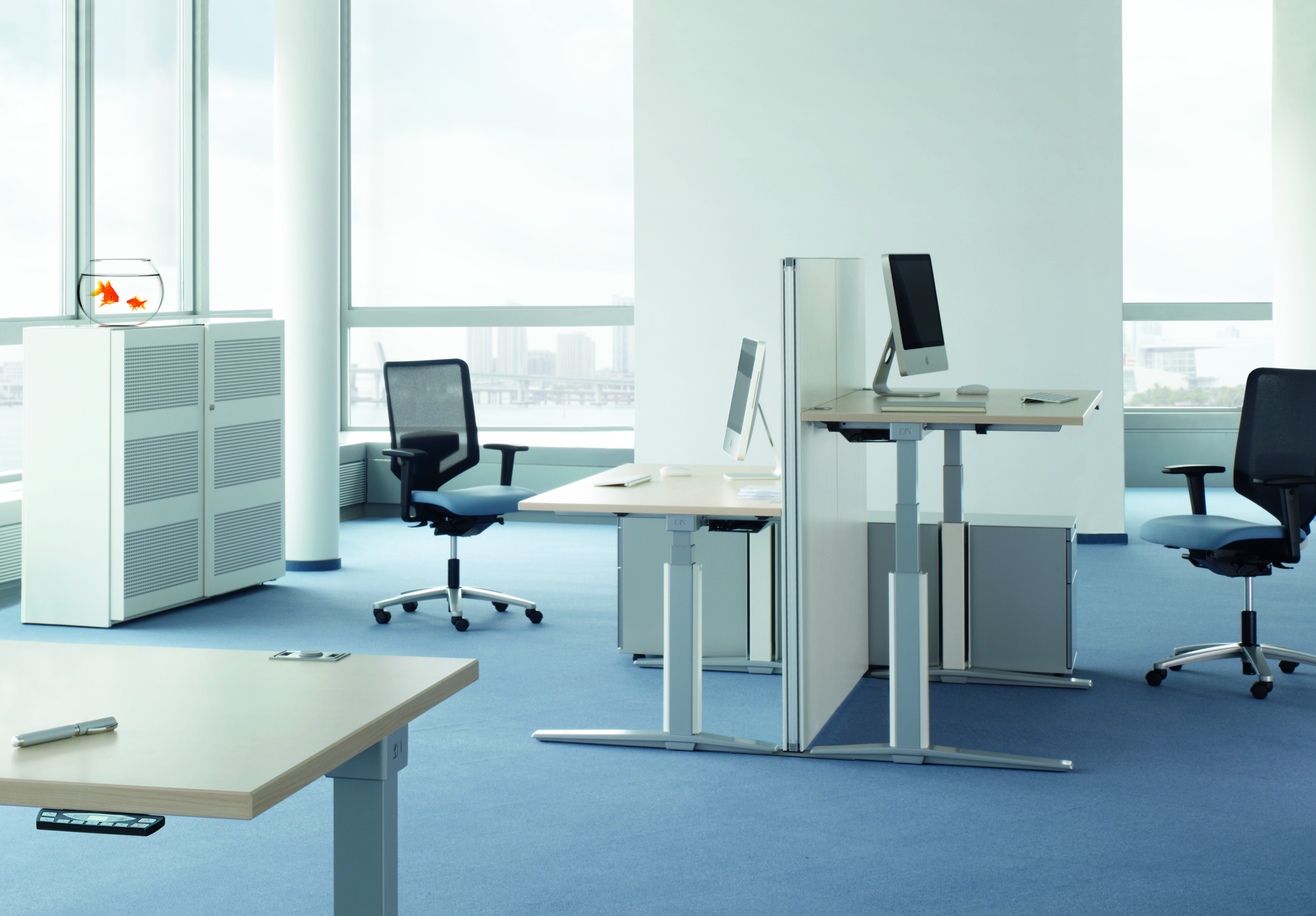 Heller Büroraum mit höhenverstellbaren Tischen, Bürostühlen und einem Talo.S Konferenztisch von König+Neurath im Vordergrund.