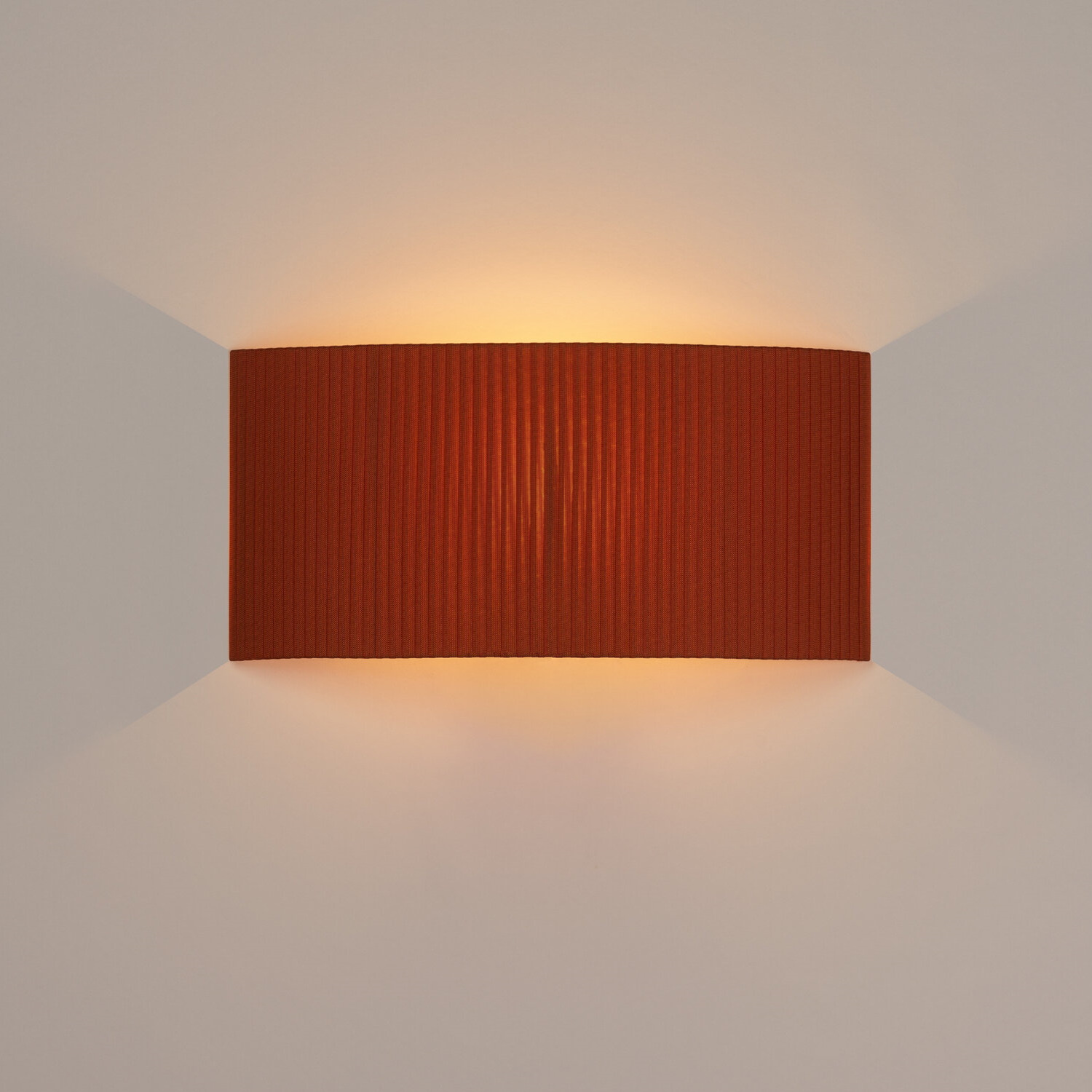 Rechteckige Wandleuchte Comodín in Terrakotta mit gerippter Textur und warmem Lichtschein.