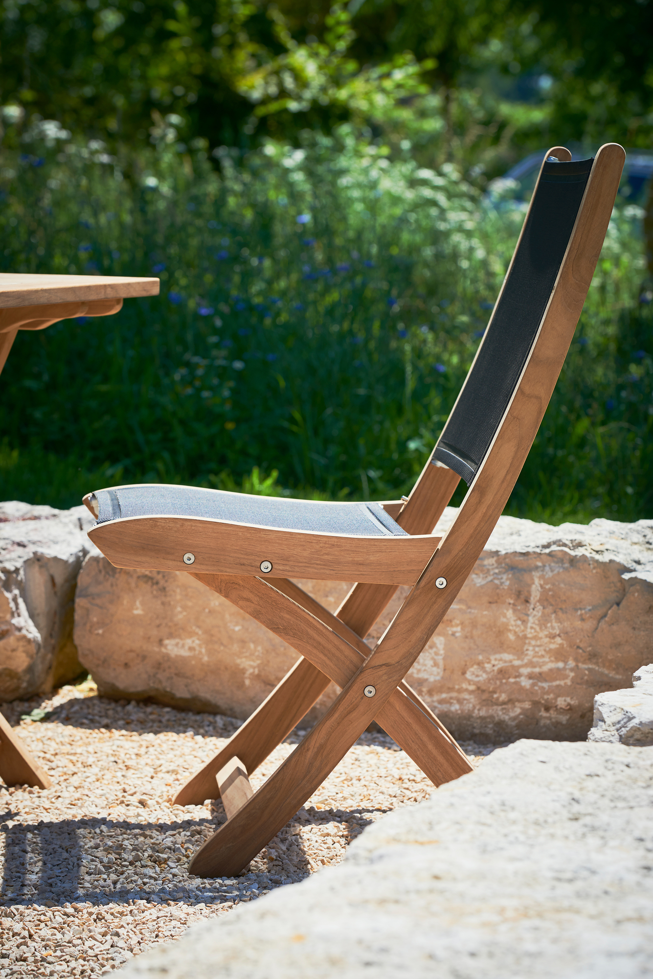 Jump Klappstuhl von Jan Kurtz, schwarzer Textilsitz und Rückenlehne, Holzgestell, Gartenmöbel für Terrasse.