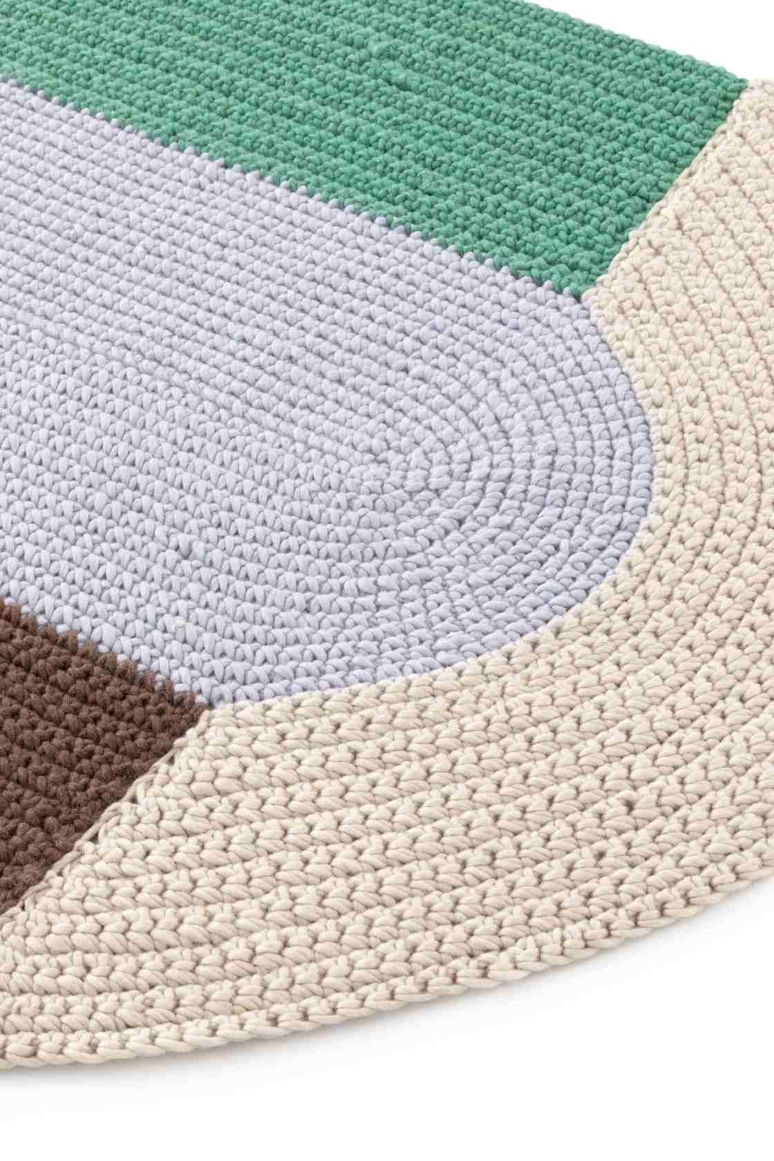 Detailaufnahme des The Crochet Collection Teppichs in Blau, Grün, Braun und Beige, gehäkelt und bestickt.