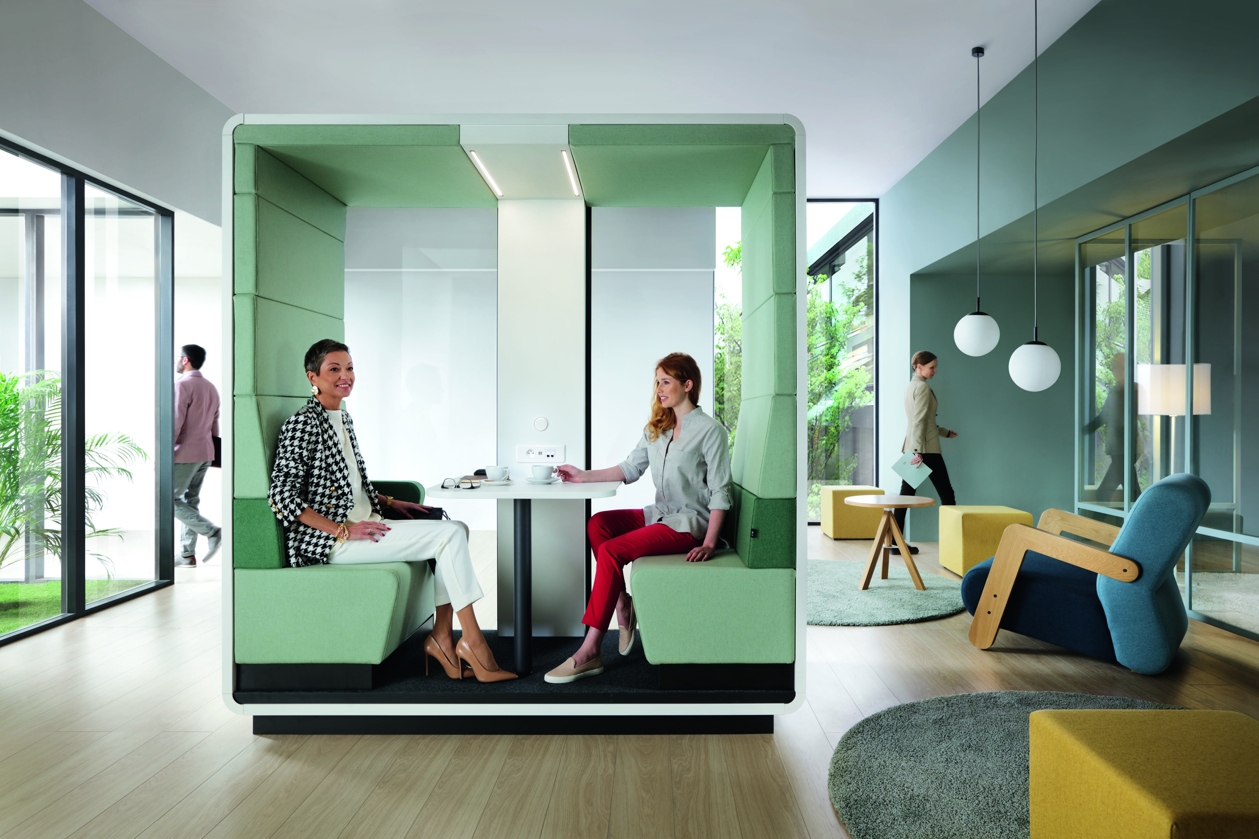 Zwei Frauen im HushMeet.Open Meetingbox von Mikomax, moderner Besprechungsraum für Büro und Konferenz.