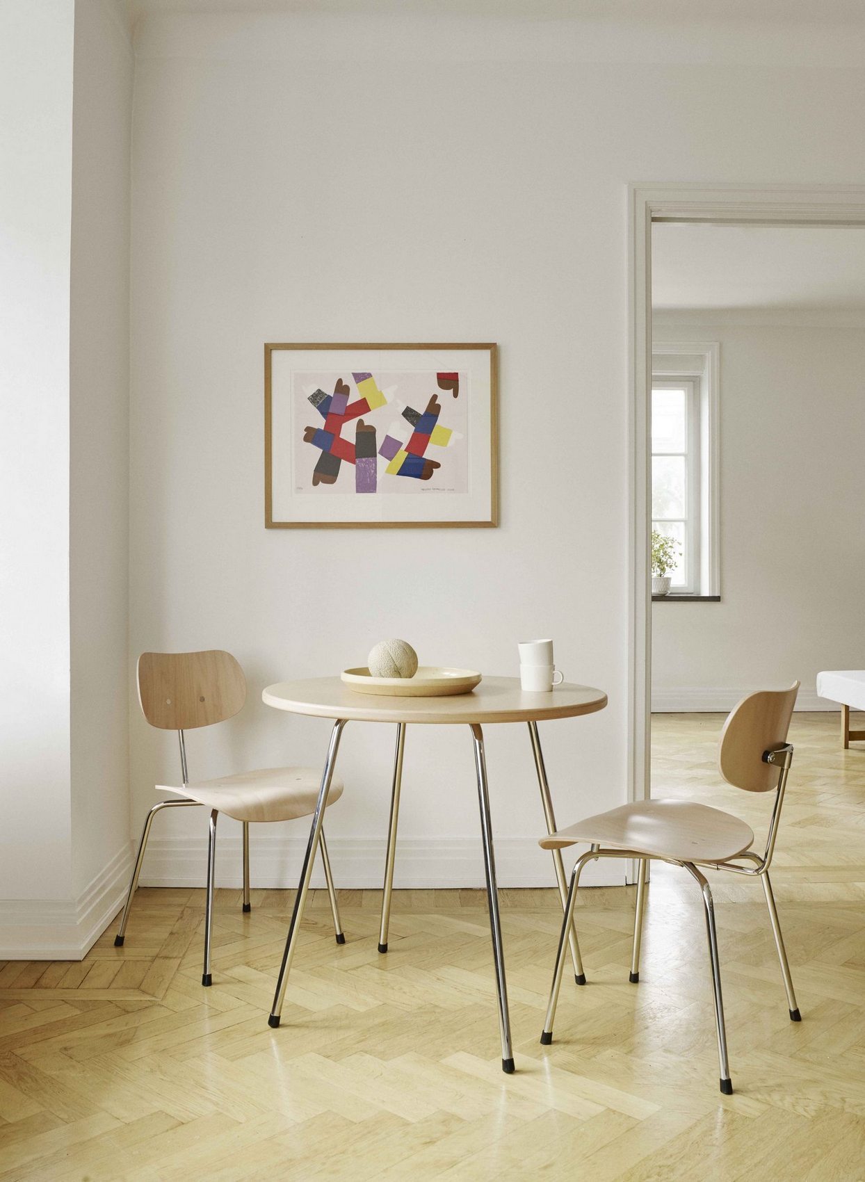 SE 330 Cafétisch von Wilde+Spieth: Runder Nussbaumtisch mit Chromgestell und zwei passenden Stühlen.