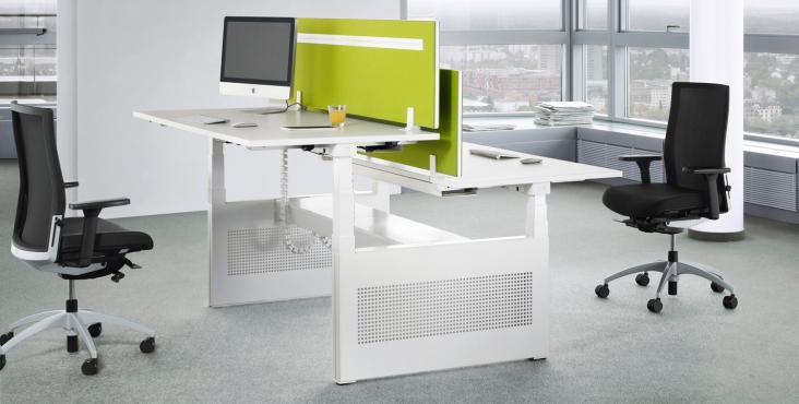 Talo.S Konferenztisch von König+Neurath, höhenverstellbar, mit grünen Trennwänden und Bürostühlen im modernen Büro.