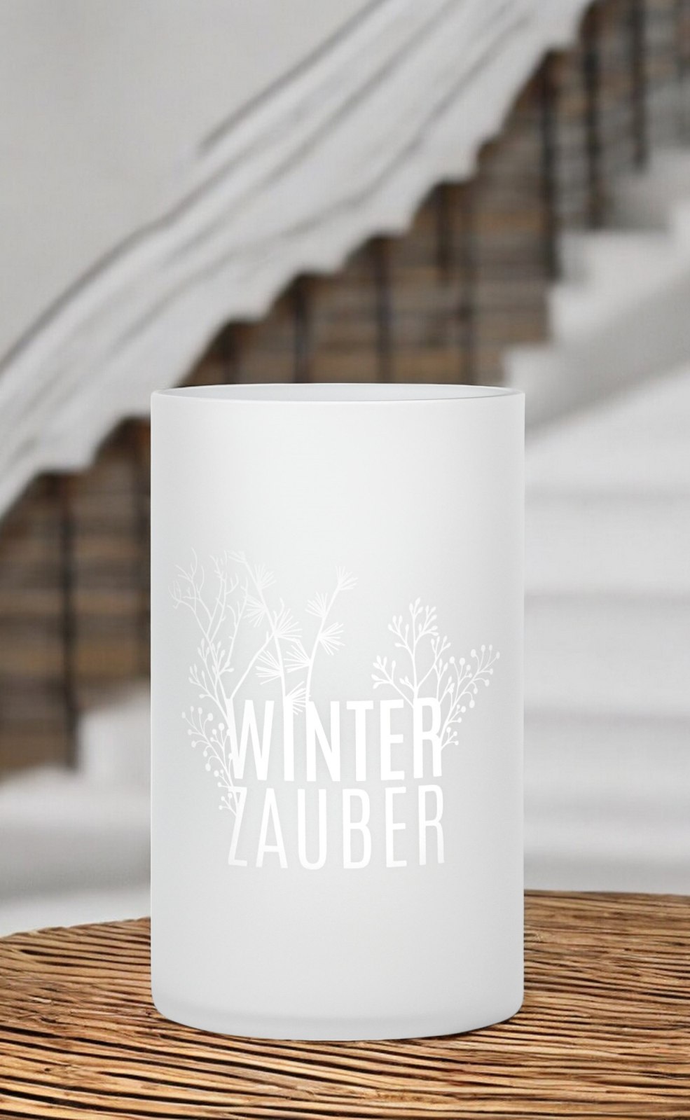 Nahaufnahme des Räder Winterzauber Windlichts, mattweiß mit filigranem Wintermotiv und Schriftzug auf einem Holztisch.