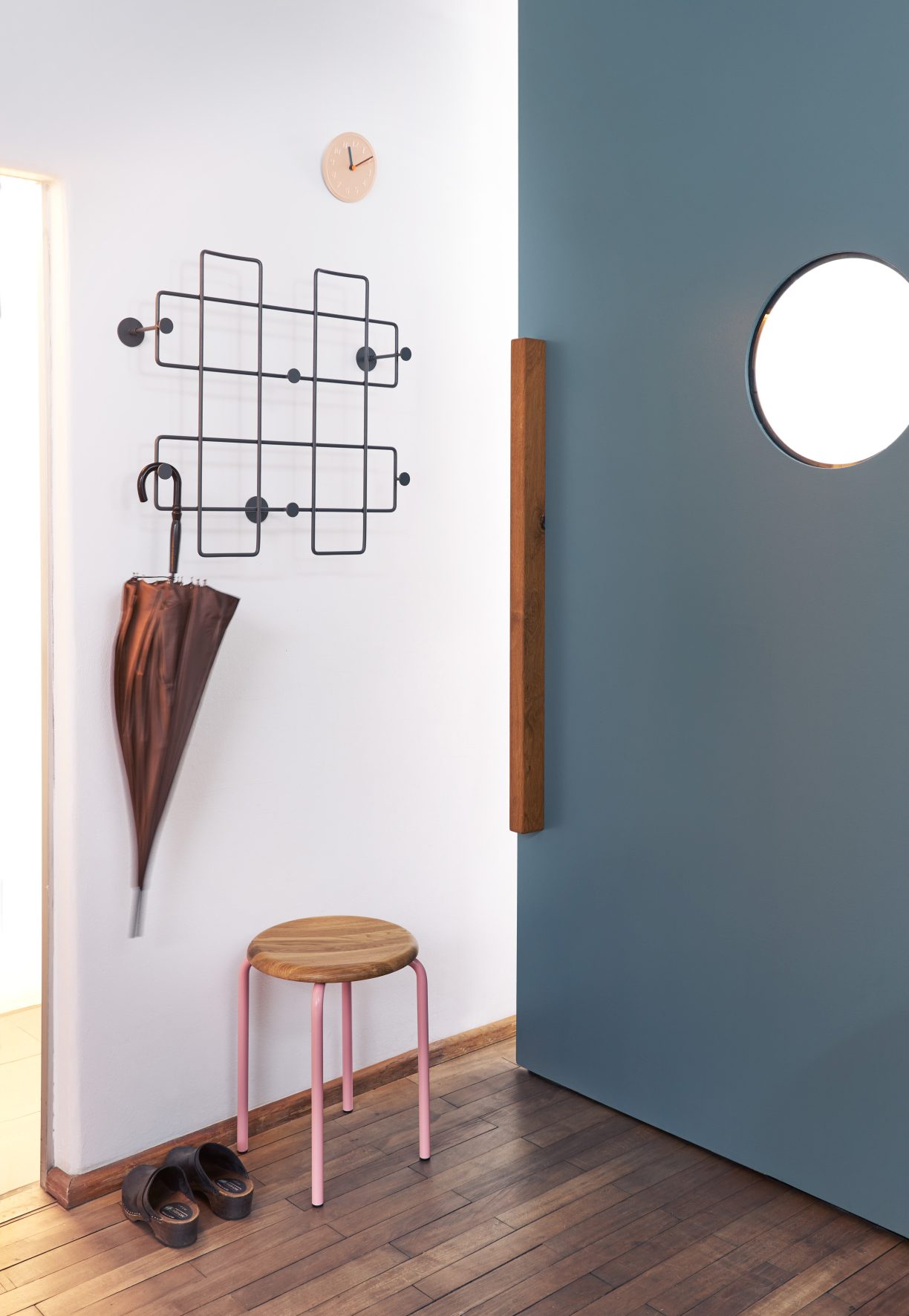 Tom Stapelhocker von Richard Lampert im Flur mit Garderobe, Schirm, Schuhen und Holzboden.