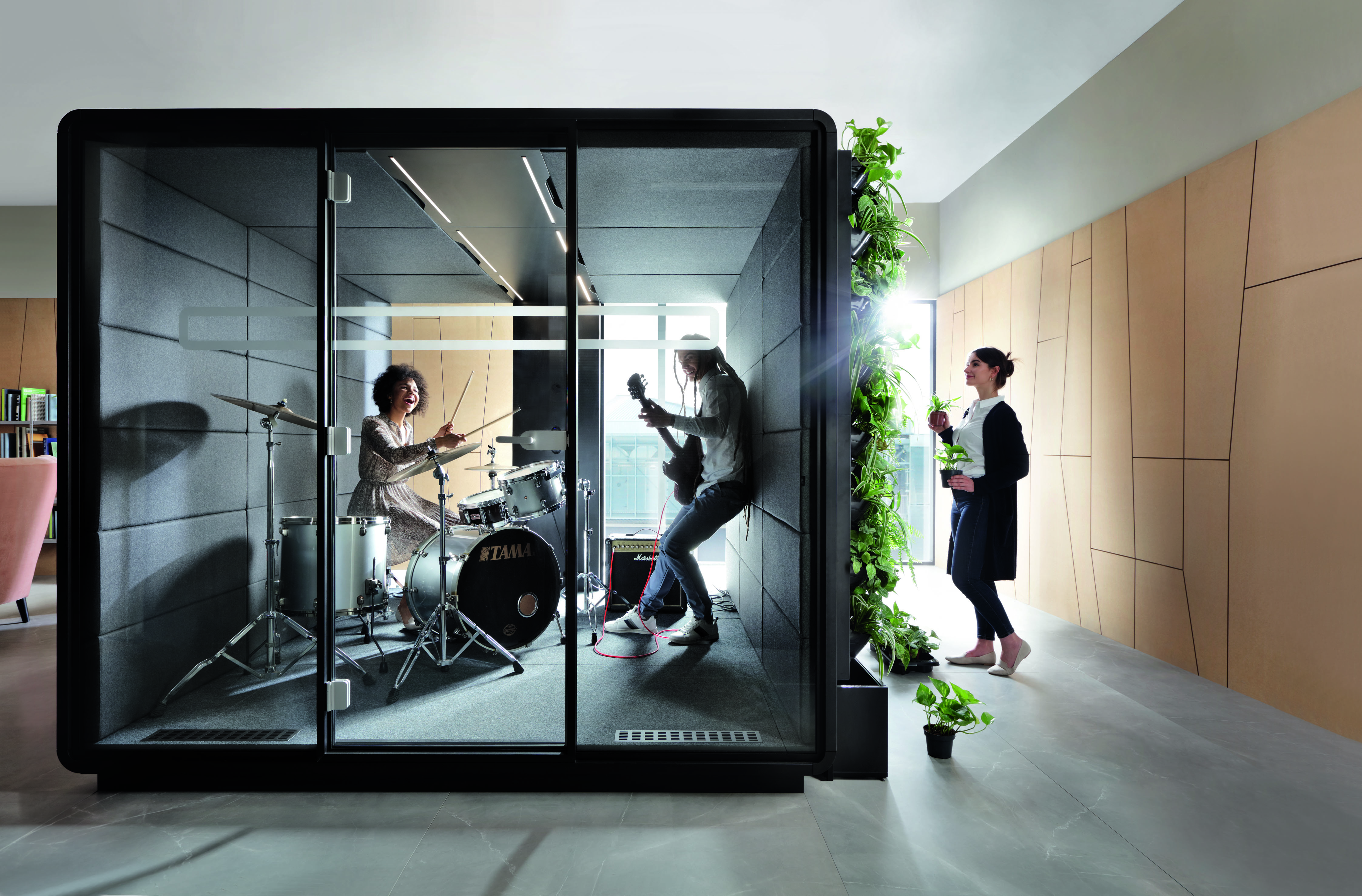 HushMeet L Meetingbox: Schallgedämmter Besprechungsraum mit Schlagzeuger, Gitarrist und Pflanzenwand im Büro.