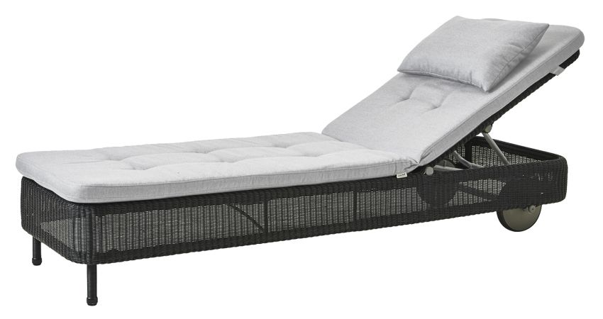 Hellgraue Cane-Line Sonnenliege mit Kissensatz und geflochtenem, dunklem Untergestell für den Garten.