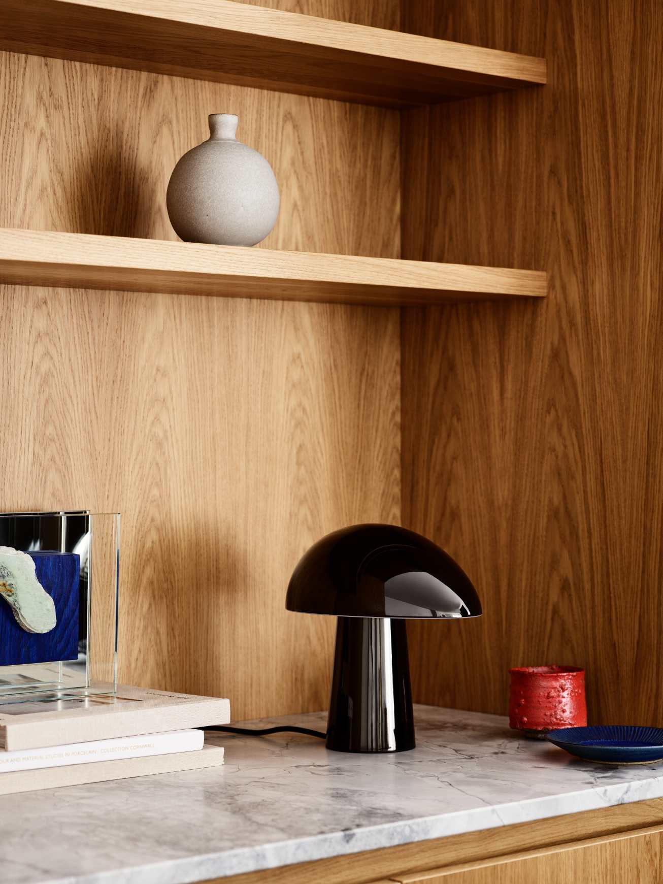 Nahaufnahme der schwarzen Night Owl Tischleuchte von Fritz Hansen auf einem Marmortisch.