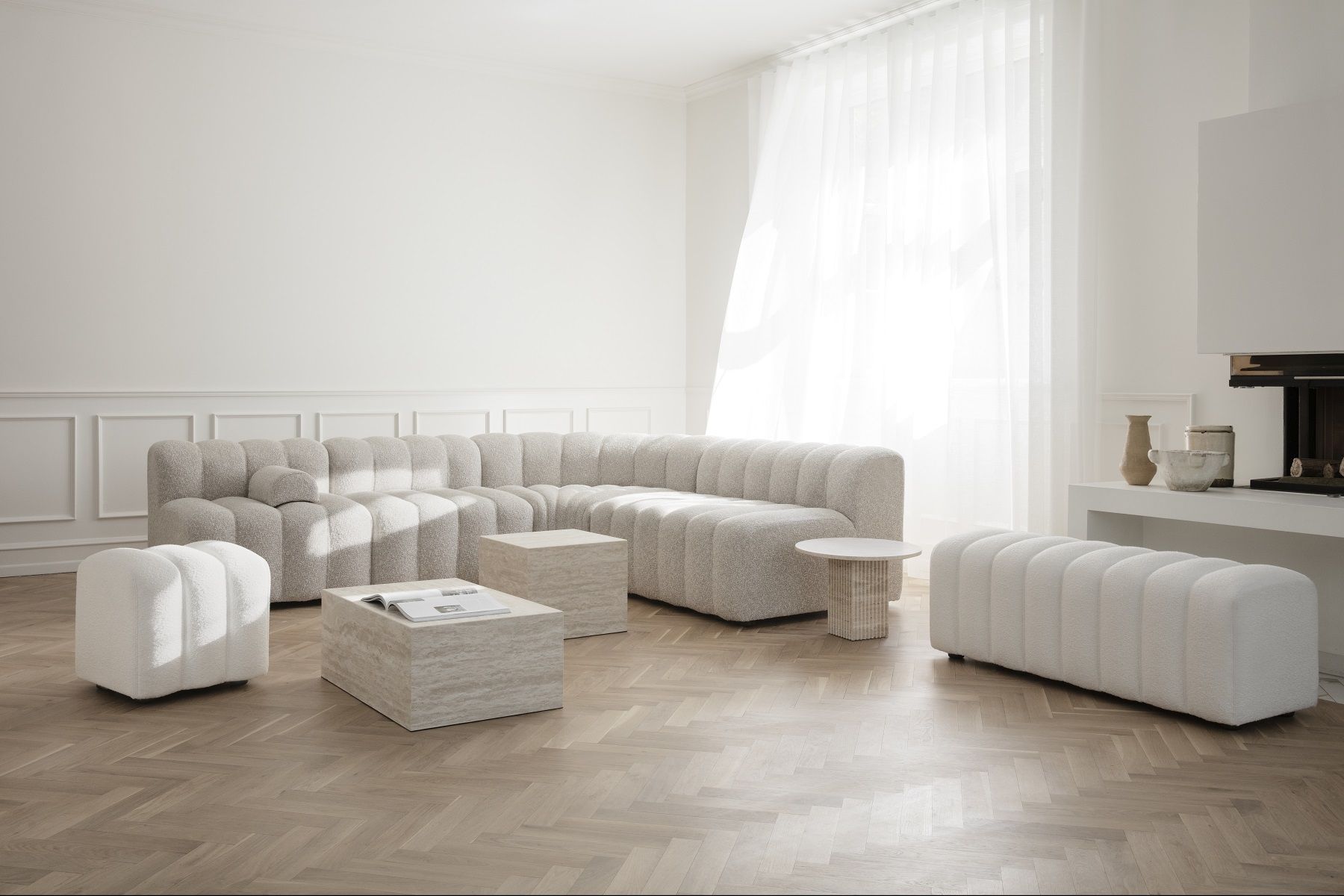 Heller Wohnraum mit modularem Sofa und Soho Couchtisch von NORR11 aus Travertin.