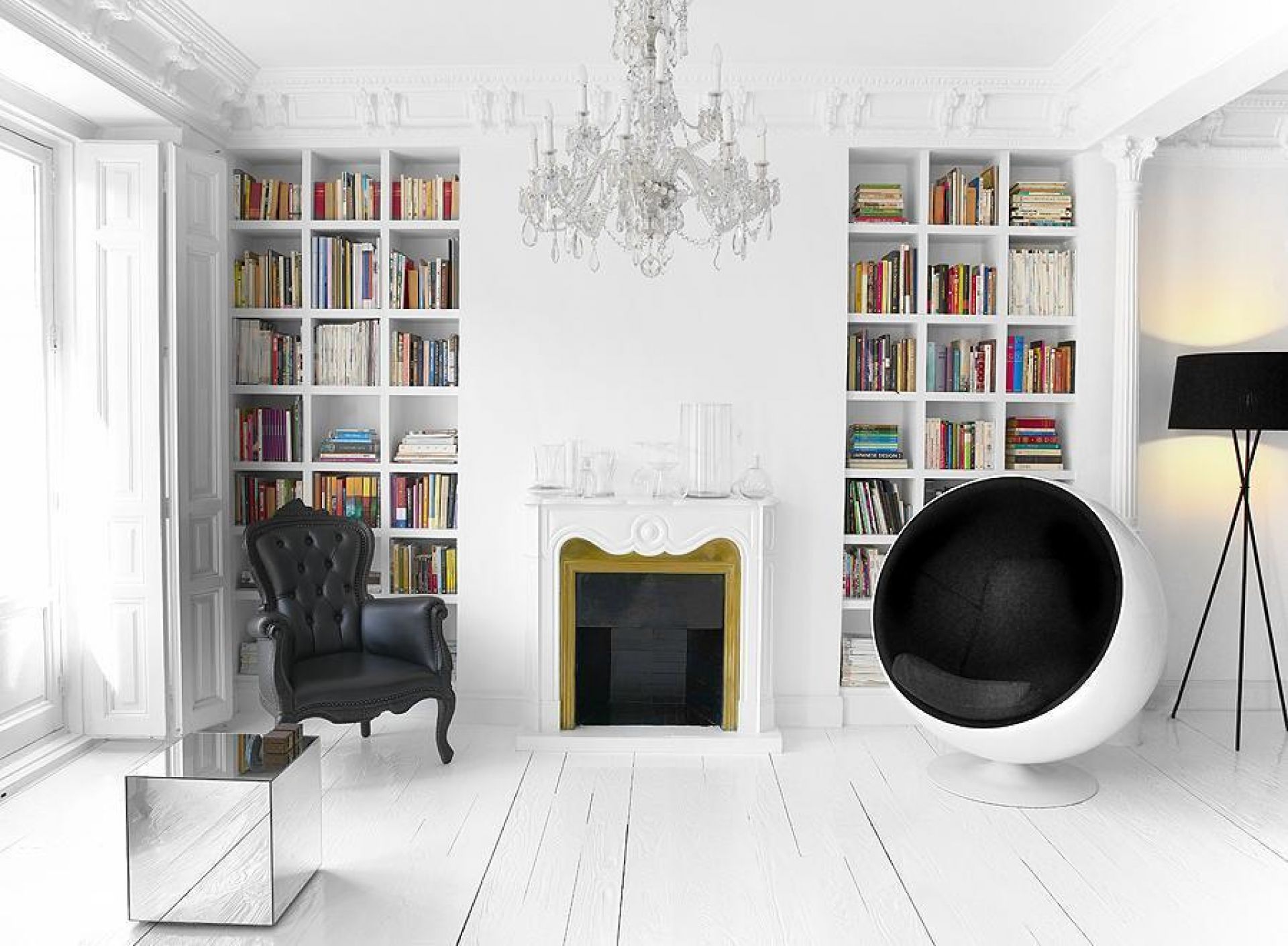 Grauer Ball Chair Sessel in weißem Wohnzimmer mit Bücherregalen und Kamin. Designklassiker von Eero Aarnio.