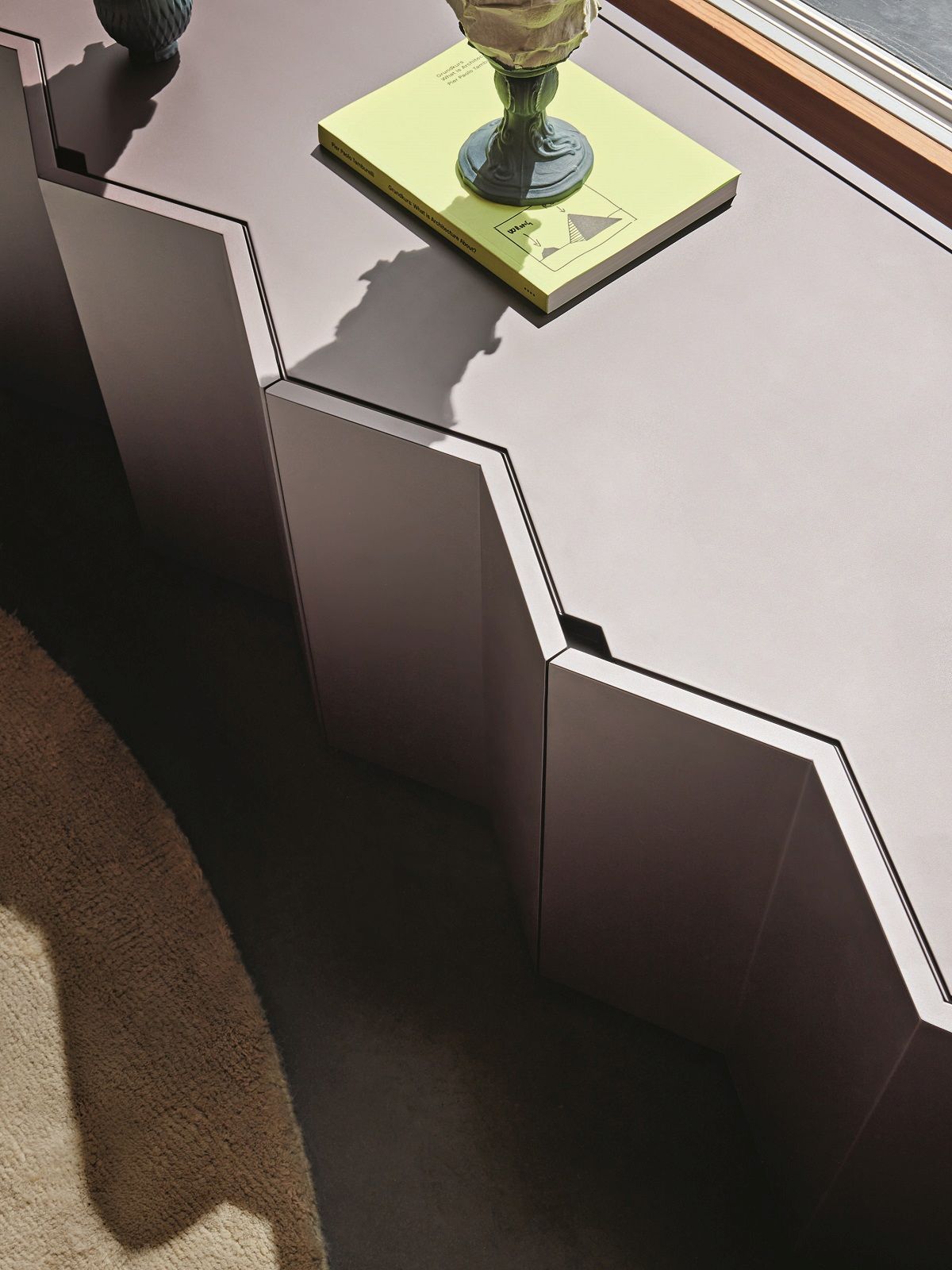 Detailaufnahme des modernen Z24 Sideboards von Zanotta, braun lackiert, mit geometrischem Design und Buch.