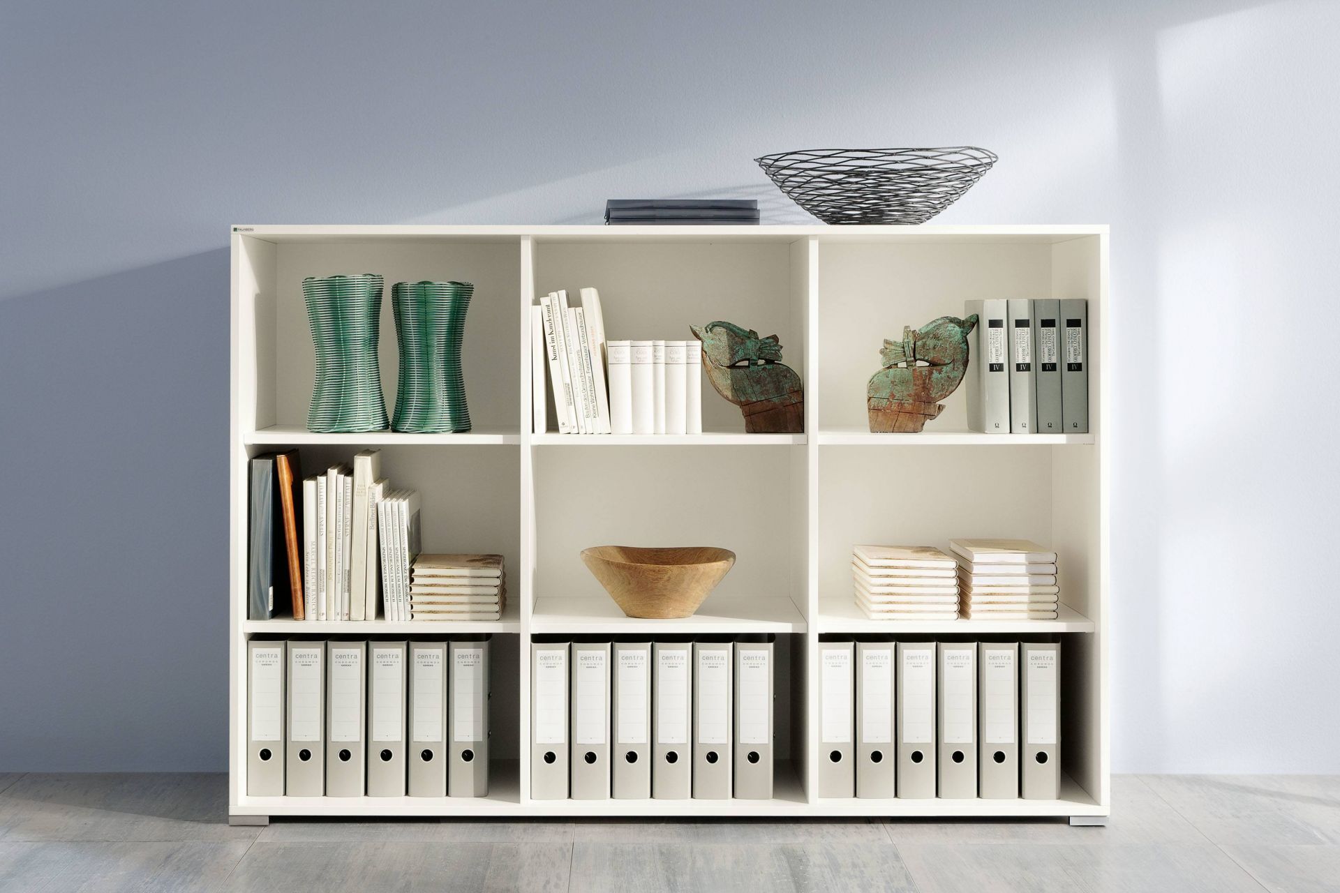 Weißer Palmberg Select Drehtürenschrank mit Ordnern, Büchern und Deko-Objekten. Büromöbel für Büro und Homeoffice.