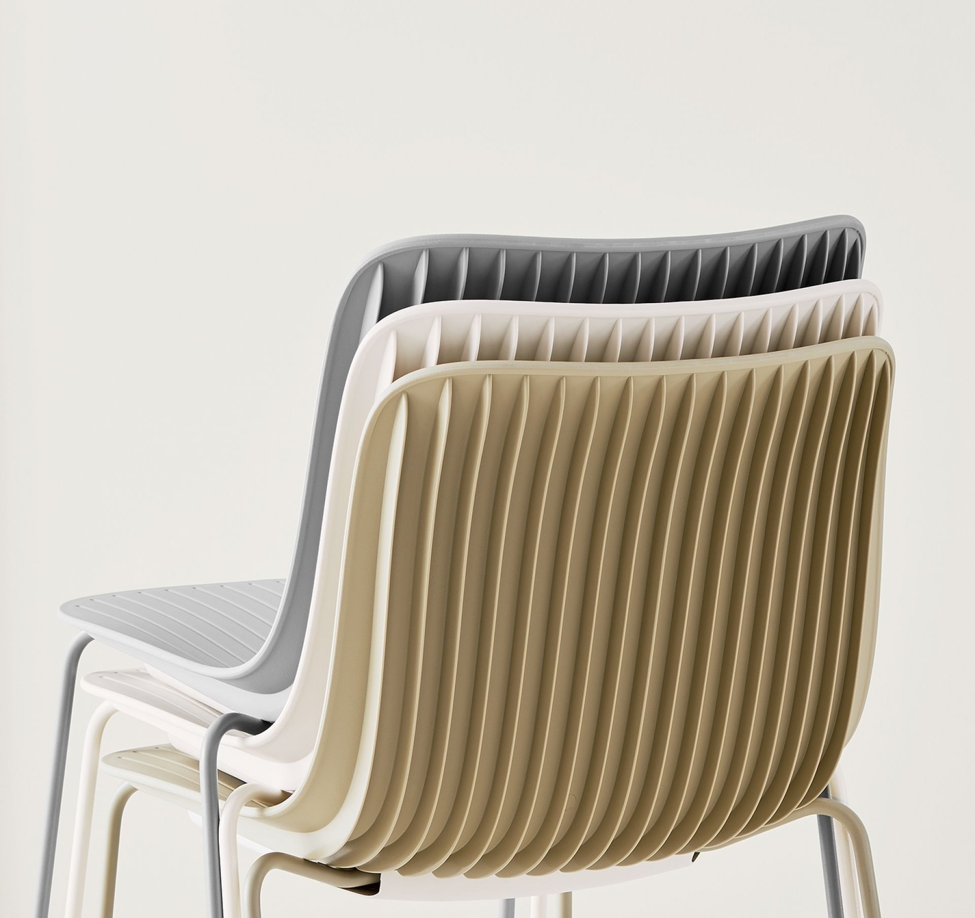 Stapelbare Dragonfly Stühle von Segis in beige, grau und weiß, Rückenlehnen im Detail.