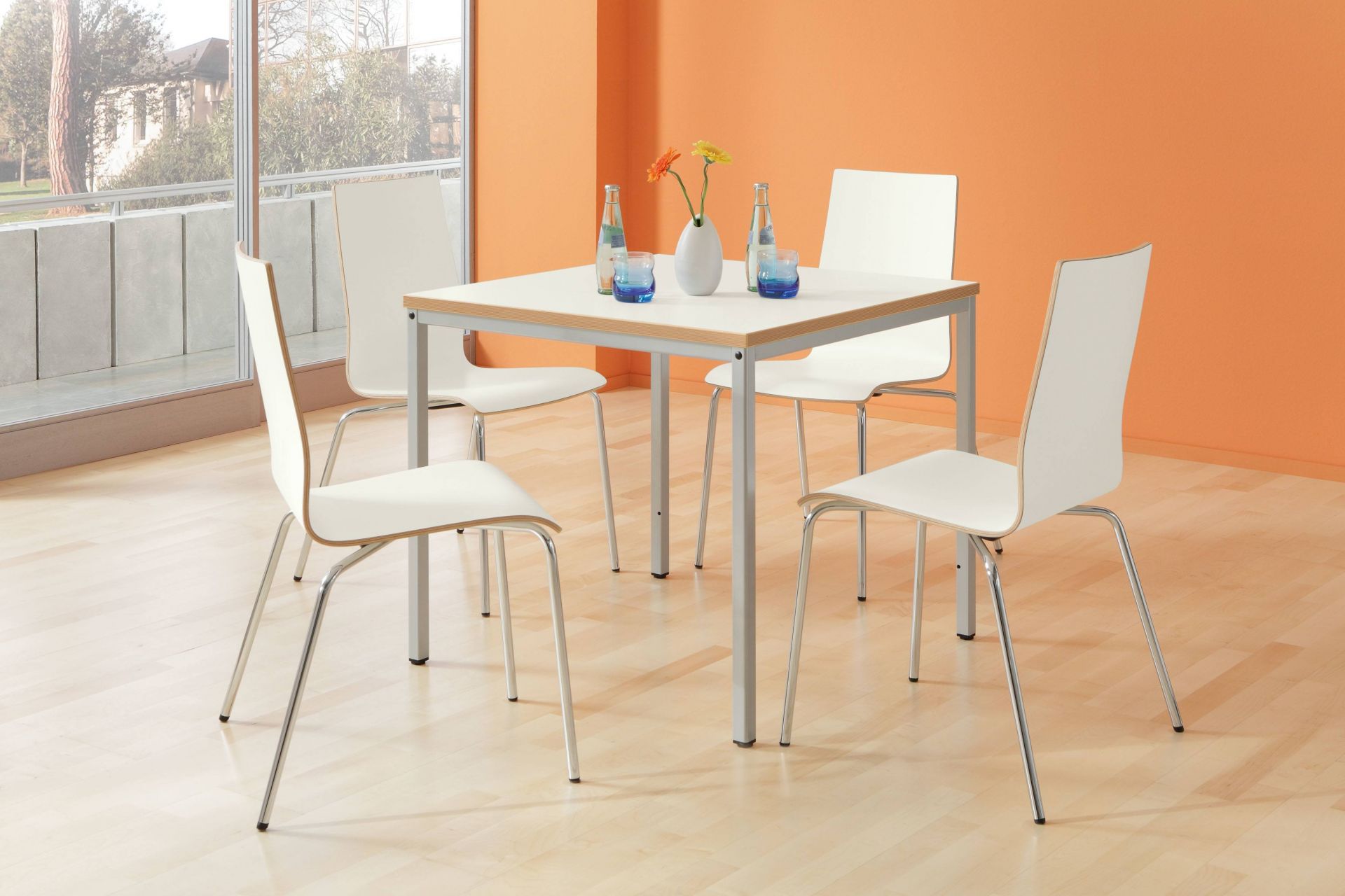 Intro Tec Besprechungstisch von Palmberg mit vier weißen Stühlen in modernem Büroambiente.