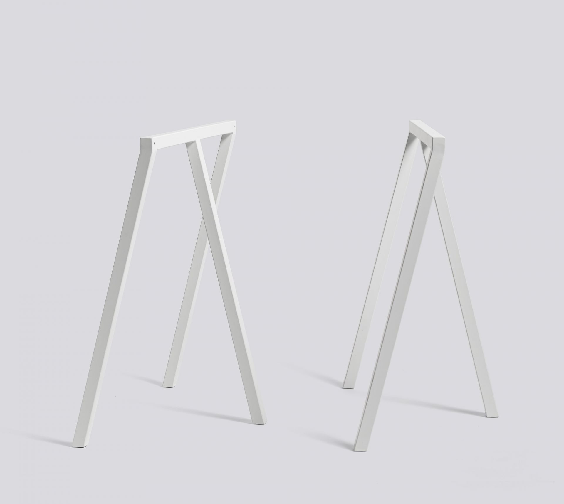 Zwei weiße Loop Stand Frame Böcke von Hay, ideal für Schreibtische und Tische.