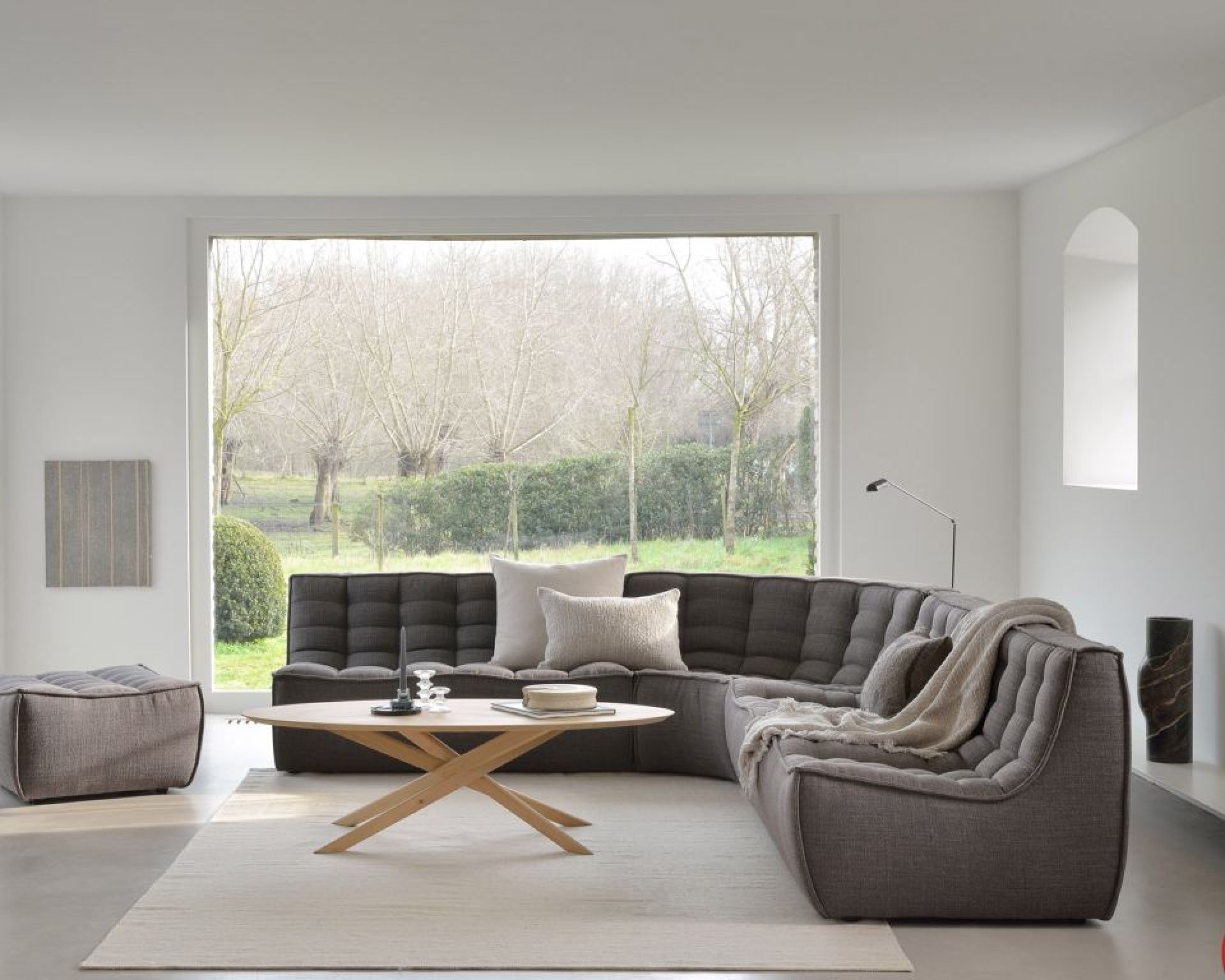 N701 Sofa von Ethnicraft mit Polsterhocker in Dunkelgrau, modernes Wohnzimmer-Interieur mit Sofa und Hocker.