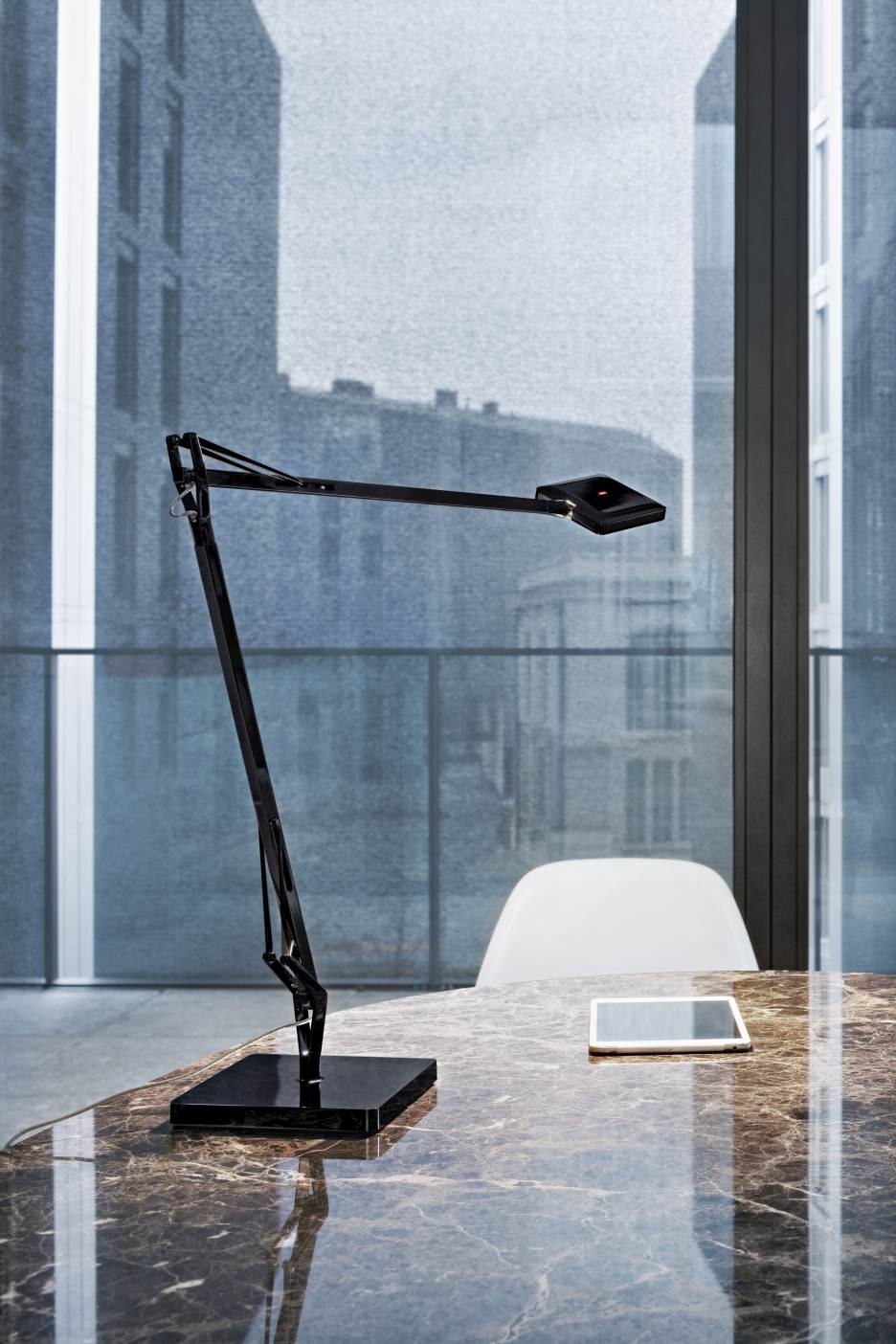 Schwarze Kelvin Edge Tischleuchte von Flos auf Marmortisch mit Tablet, modernes Design.