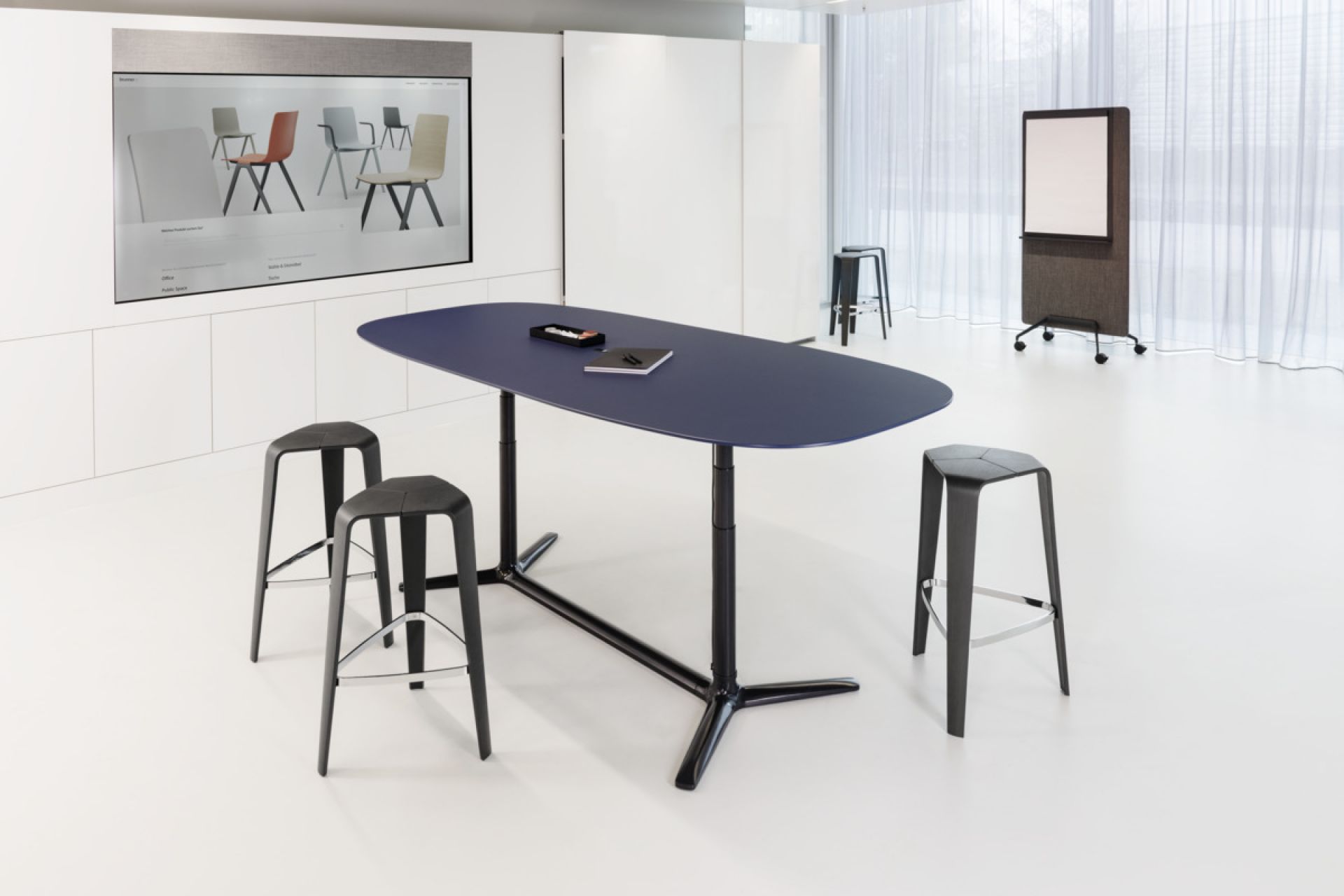 Blauer Brunner Konferenztisch, höhenverstellbar, mit schwarzen Barhockern in modernem, hellem Konferenzraum.