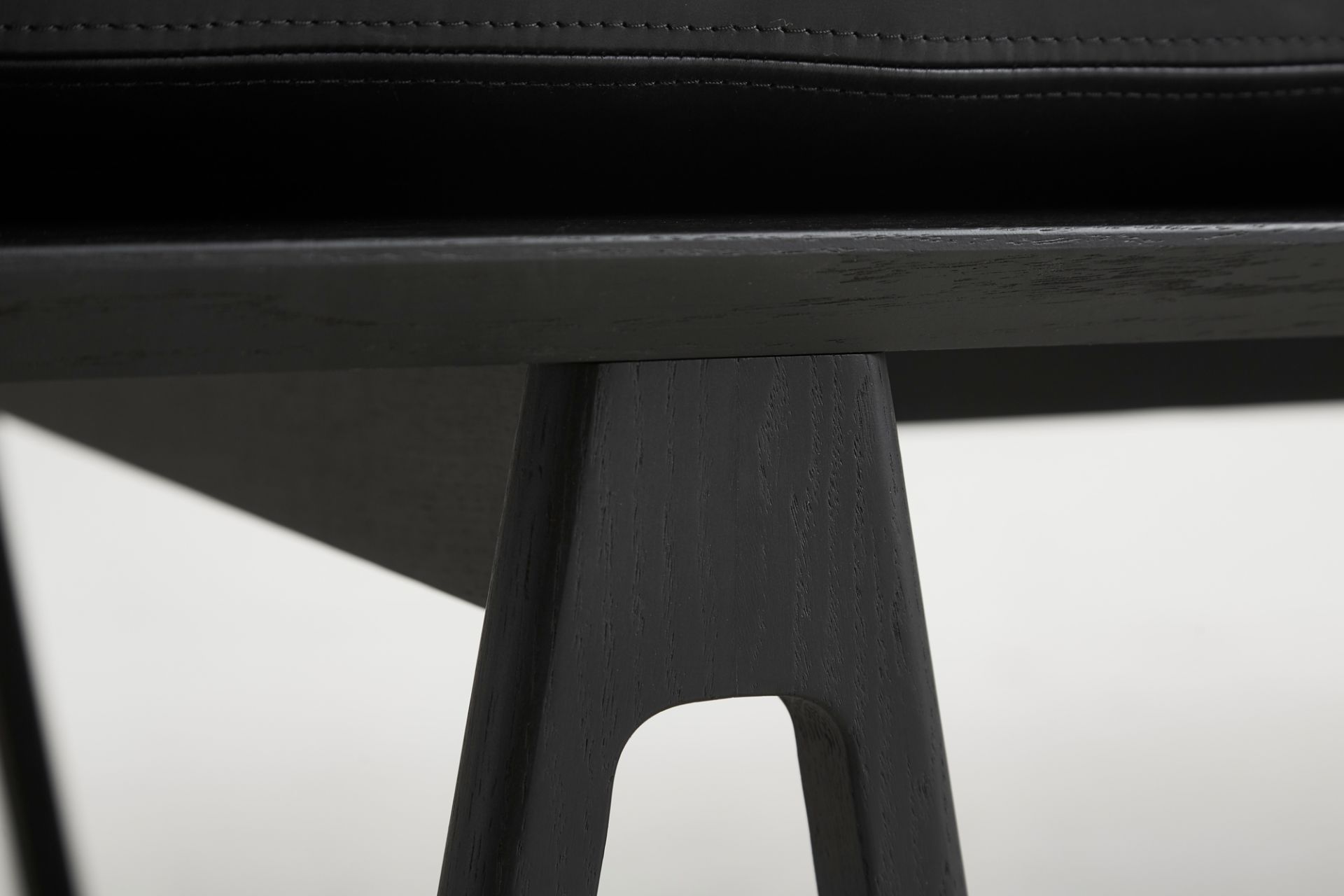 Detailaufnahme der schwarzen Holzbeine der Level Daybed Liege von Woud.