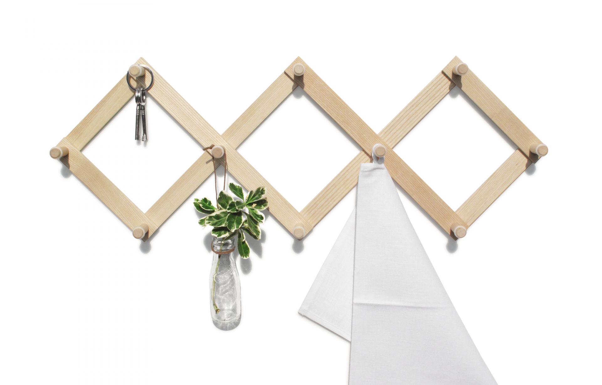 Helle Holz Wandgarderobe Lia Side by Side mit Schlüssel, Pflanze und Handtuch an weißer Wand.