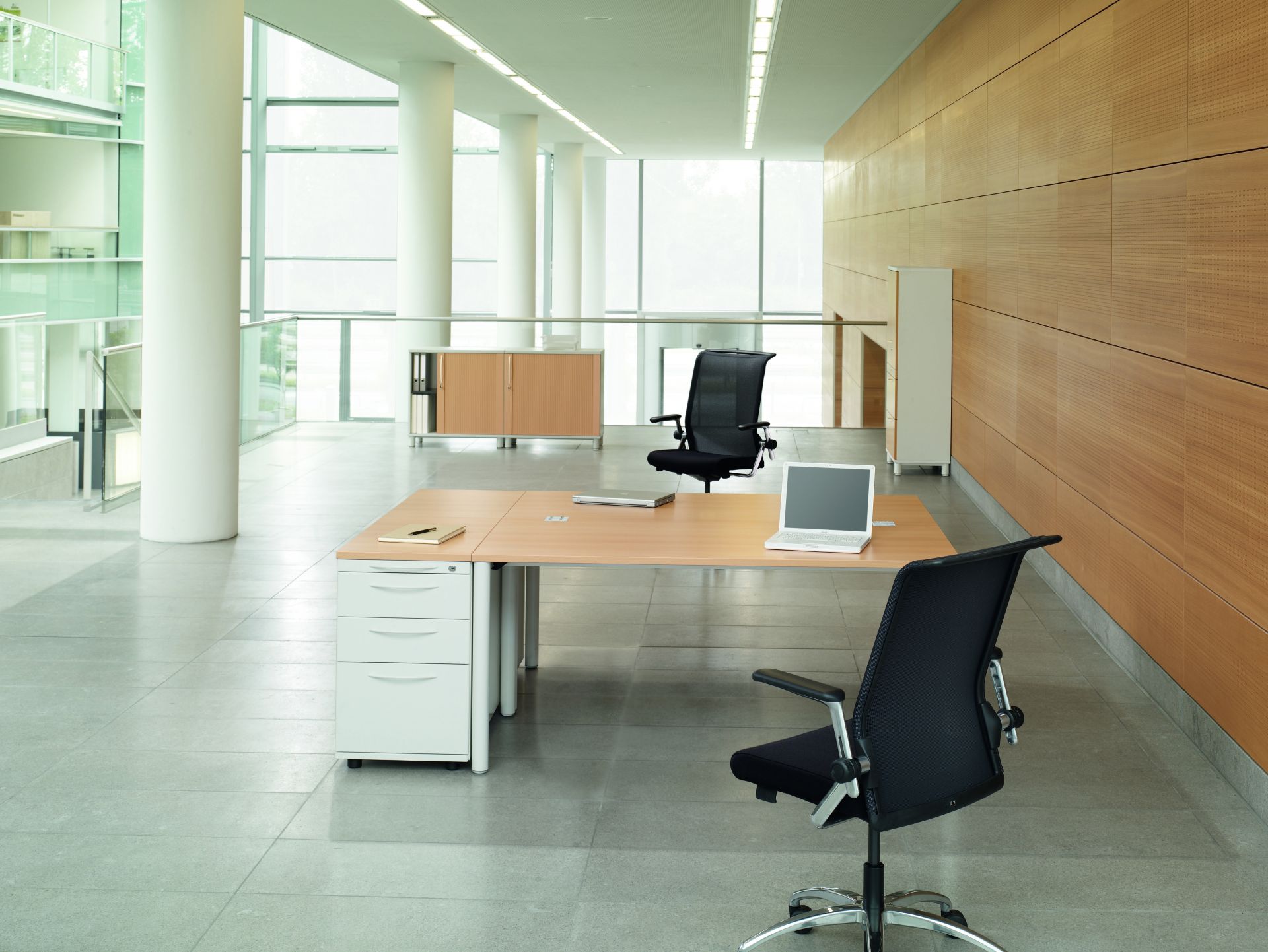 König+Neurath Basic 4 Besprechungstisch in Bootsform mit Bürostühlen und Laptop in modernem Büro.