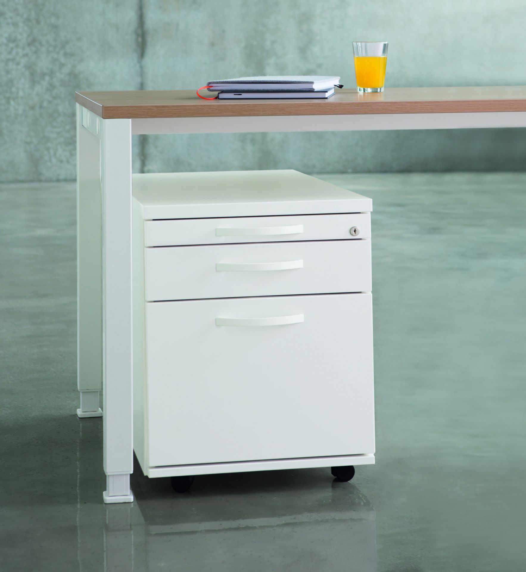 Weißer Rollcontainer von König+Neurath mit drei Schubladen unter einem Schreibtisch, Büromöbel für die Büroorganisation.