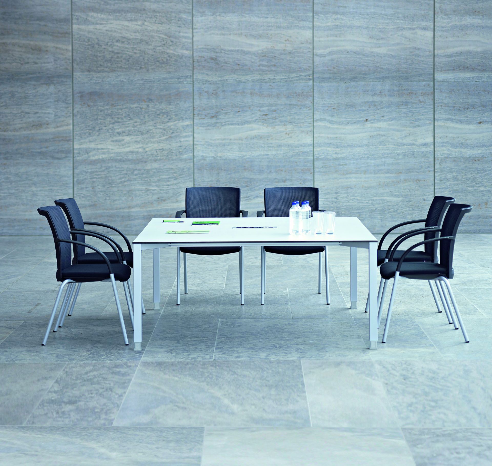 Basic 4 Besprechungstisch von König+Neurath mit Bürostühlen, Wasserflaschen und Gläsern in einem modernen Büro.