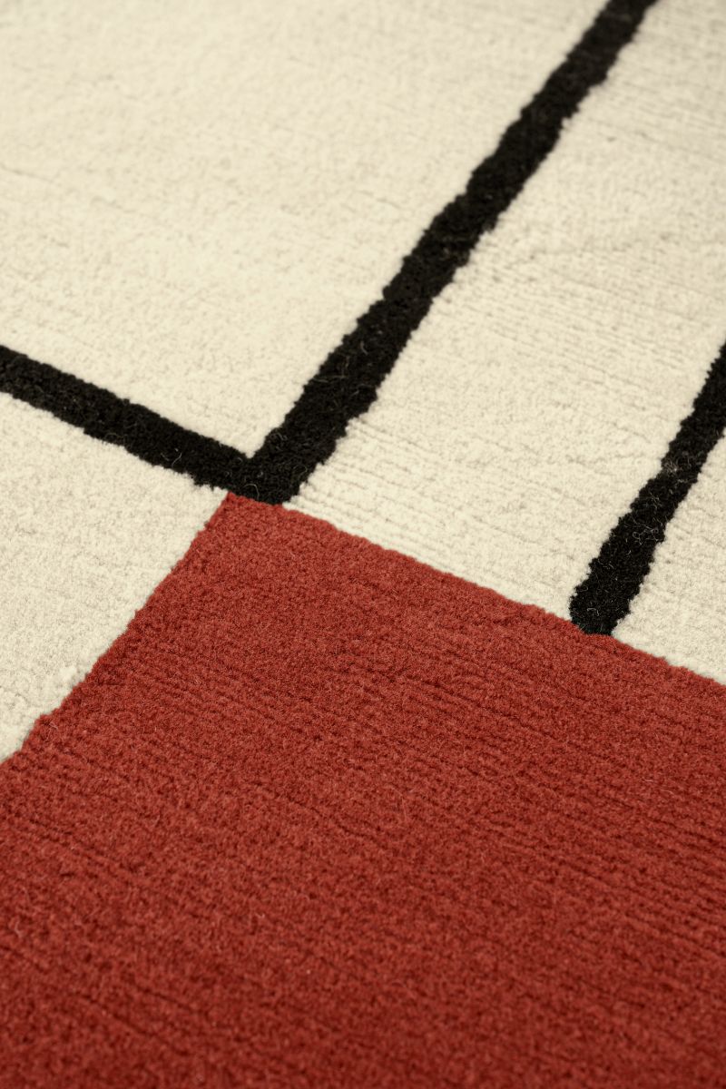 Detailaufnahme des ClassiCon Wendingen Teppichs 300x250cm mit geometrischem Muster in Rot, Schwarz und Beige.