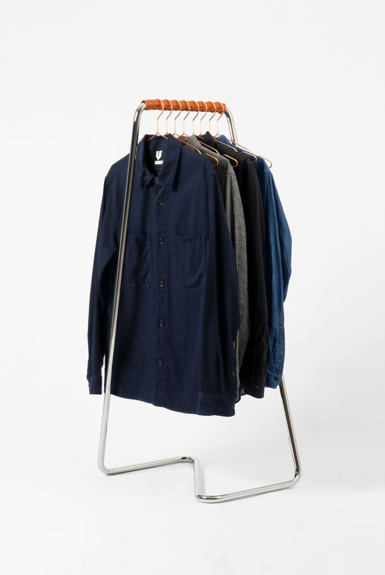 Z10 Garderobenständer von Tecta aus Edelstahl mit Cognac Manschette und hängenden Hemden.