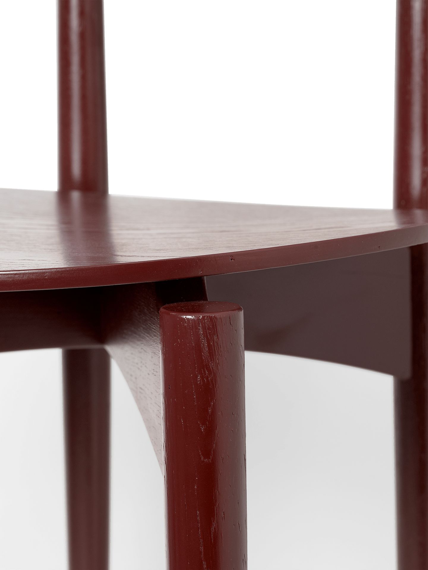 Detailaufnahme des Herman Esszimmerstuhls von Ferm Living mit rotbraunem Holzgestell. Stuhl Design Möbel.