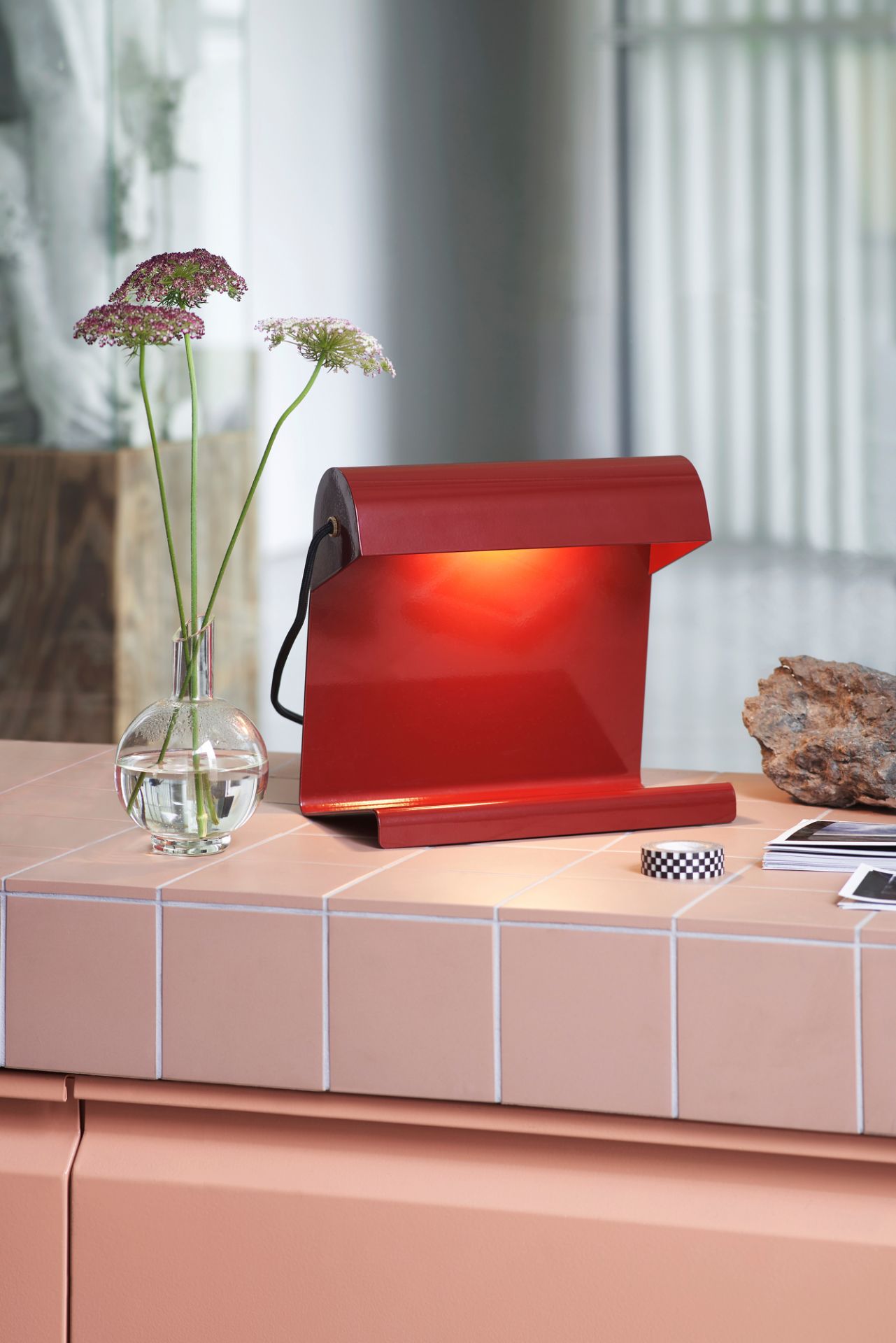 Rote Vitra Tischleuchte auf einem Tisch, modernes Design für Büro und Zuhause.
